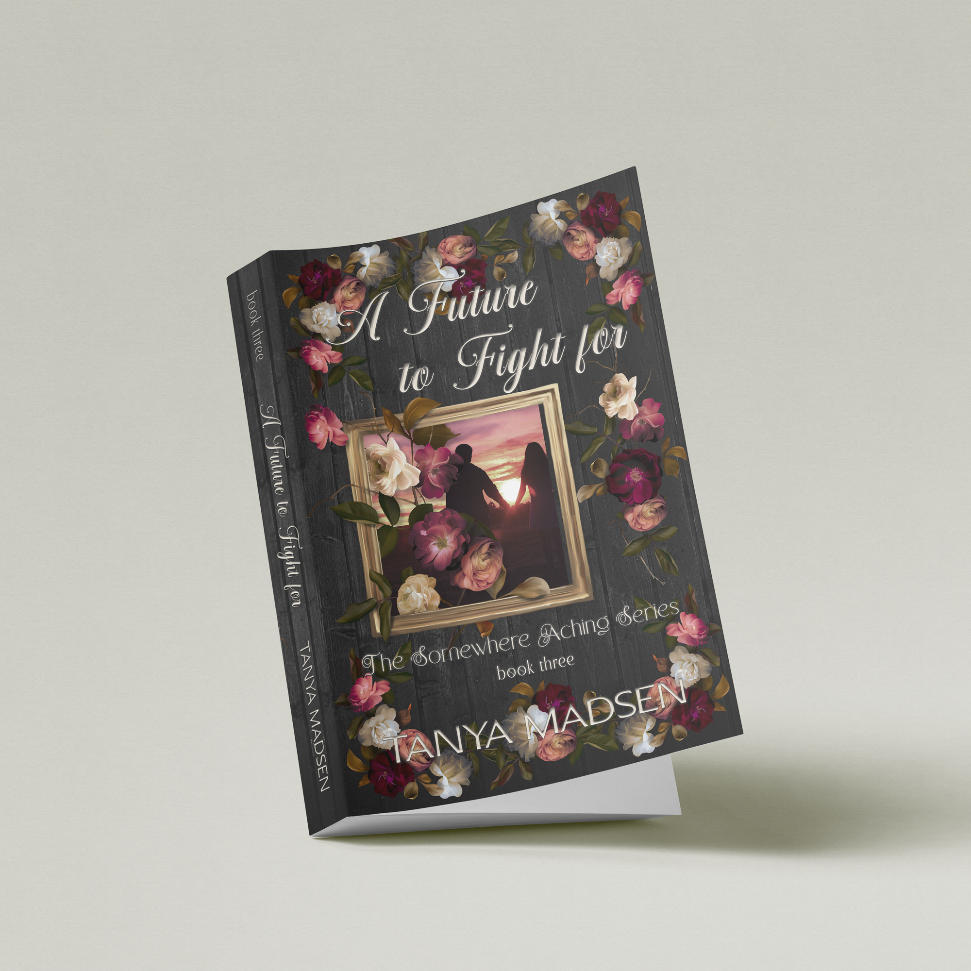 A partial side view image of the book A Future to Fight For, surrounded by a floral design. The cover shows a silhouette of a couple holding hands staring at the sunrise. The book is set against a sage‑green background.