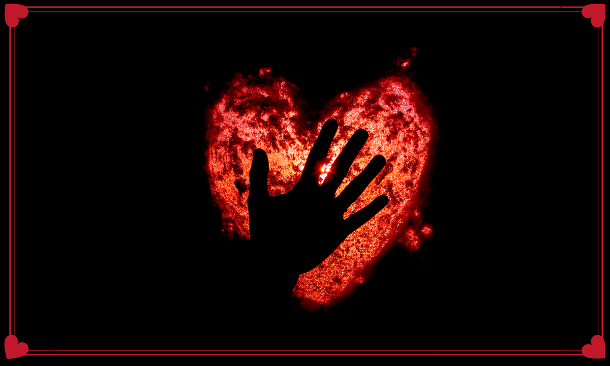 Heart-shaped light with a hand silhouette against a dark background
