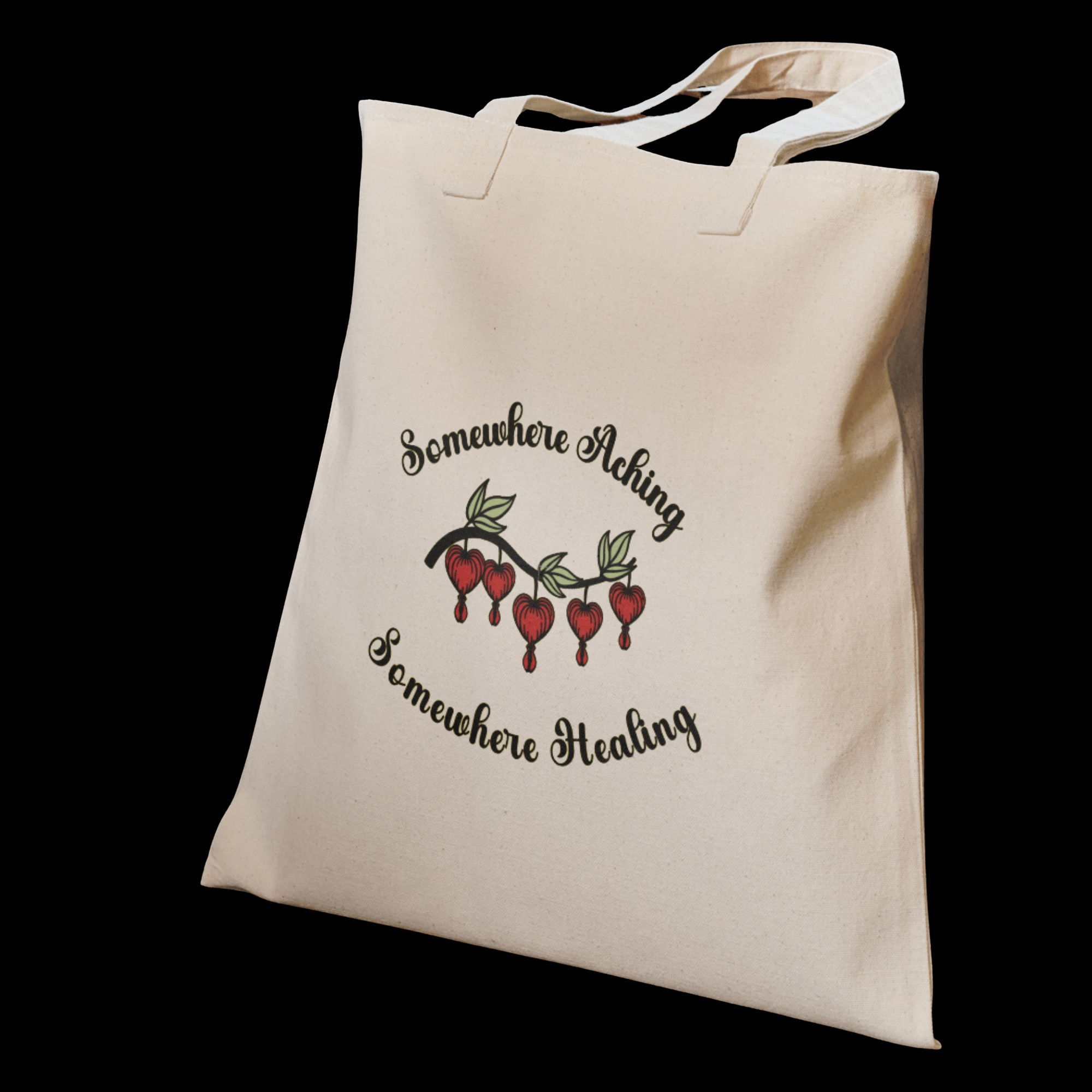 A canvas tote illustrated with the quote “Somewhere Aching, Somewhere Healing” paired with a cluster of bleeding hearts.