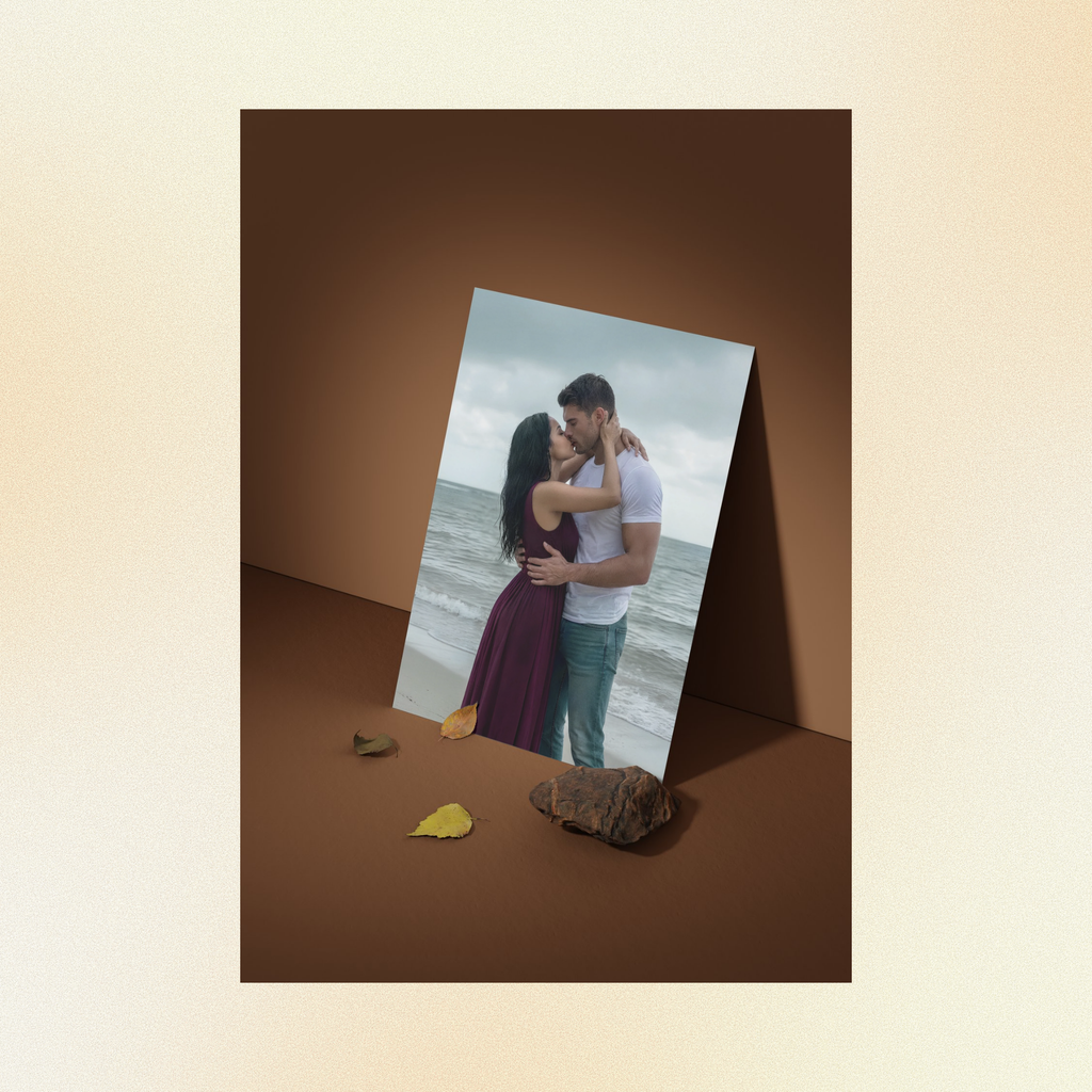 A photo displayed against a brown wall of Judith and Judith embracing passionately in front of a stormy ocean. 