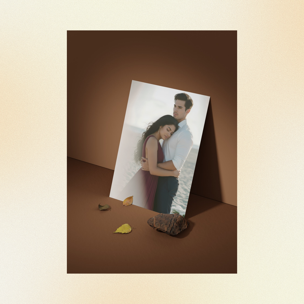 A photo displayed against a brown wall of Judith hugging Nicolas in front of the ocean her head laying against is chest, her expression is one of serenity and joy, his eyes reflect pure contentment.
