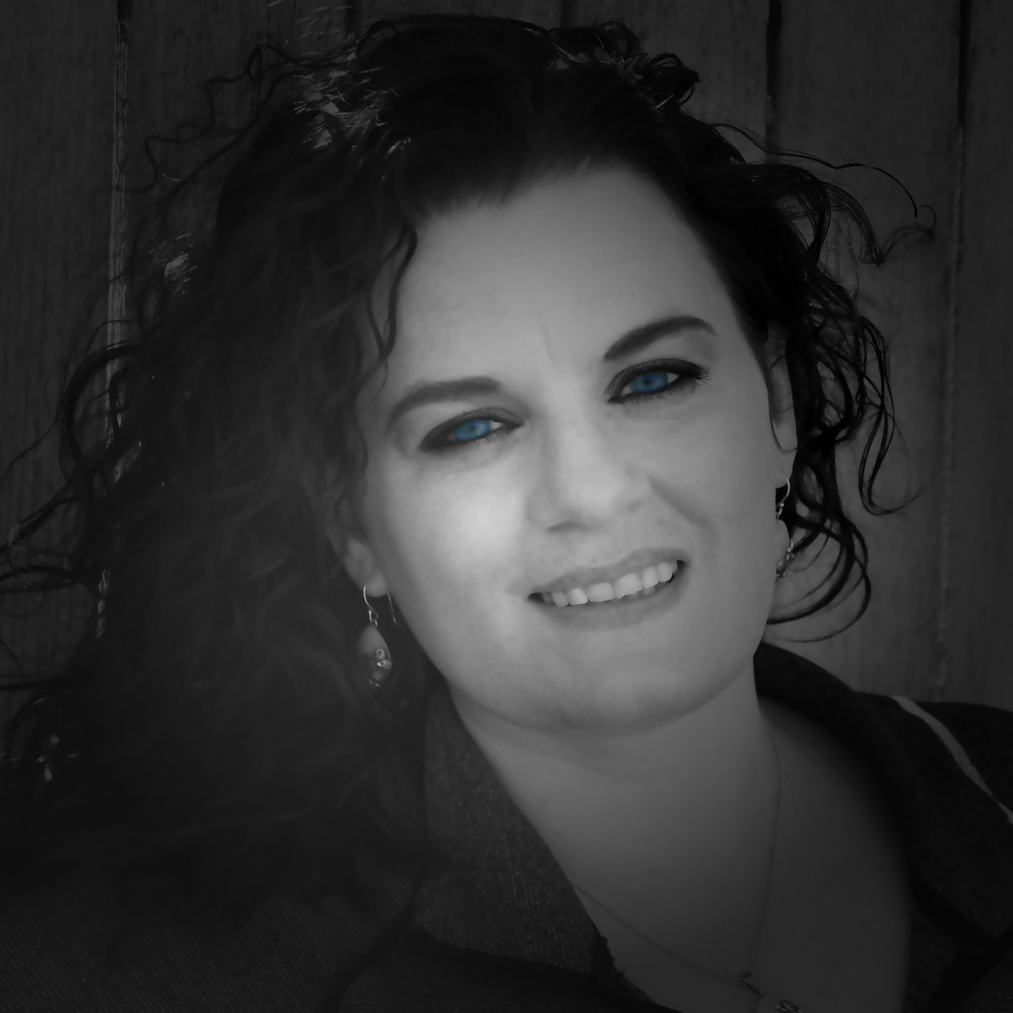 Black and white portrait of a woman with dark hair and blue eyes.