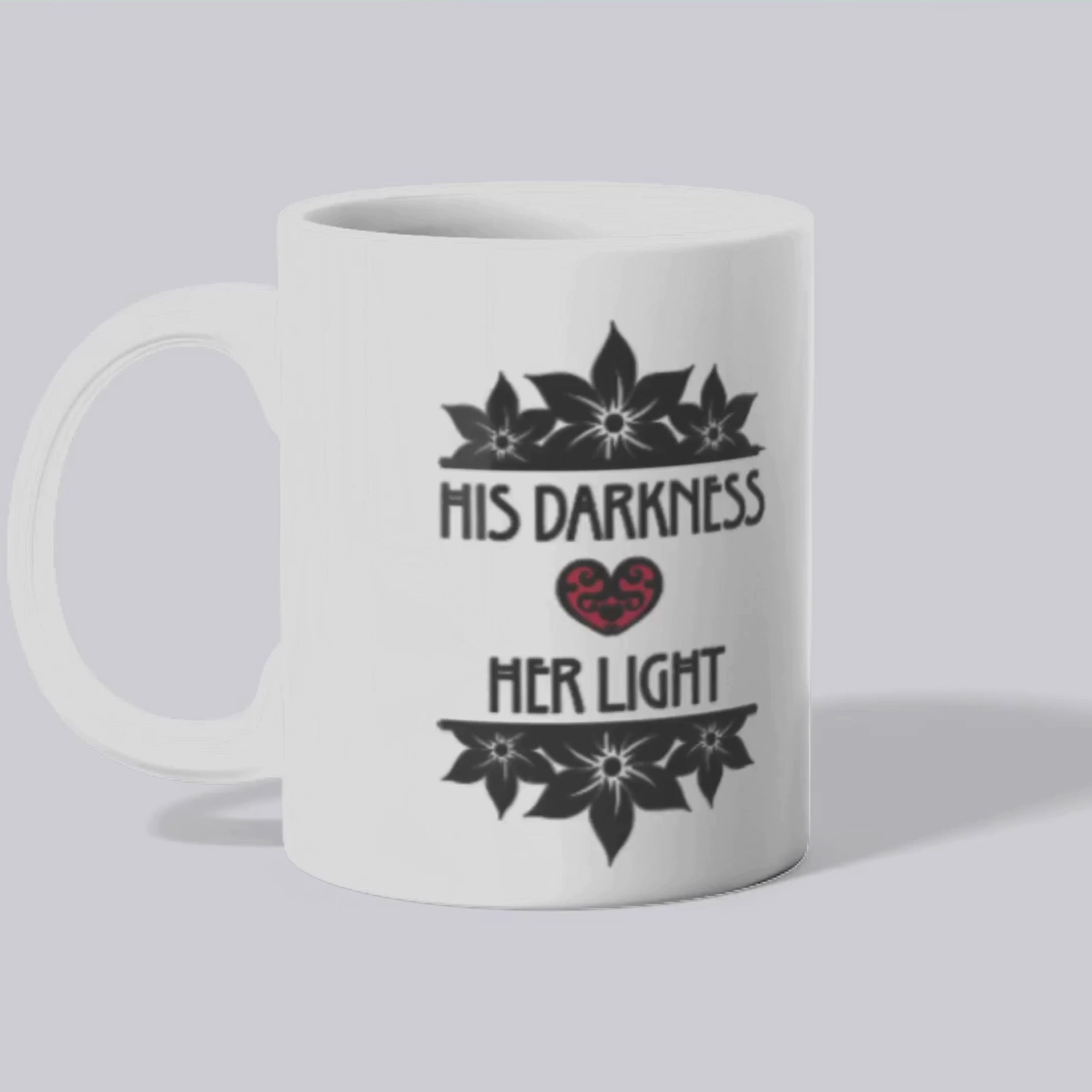 A mockup of the broken boy and angry girl mug featuring black text that says "his darkness, her light, his madness, her fight" with designs of black belladonna flowers on a white background.
